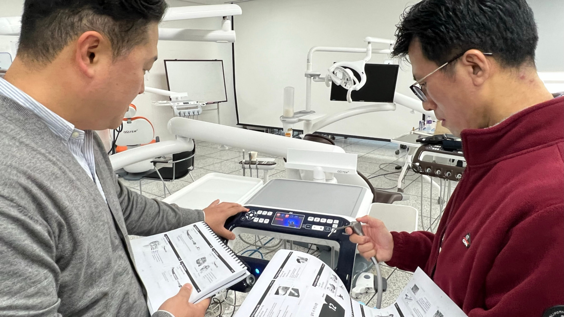 Engineers from Osstem Implant’s overseas smart dental service division and smart dental education research and development centre checking the installation manual of their dental chair unit.