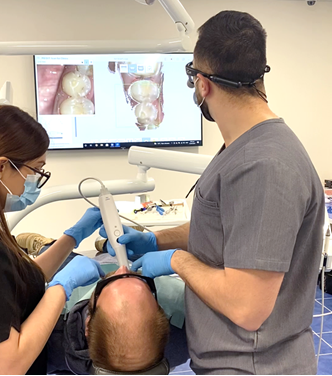 Fig. 3: An example of scanning a patient. Note that both my dental assistant and I are retracting the cheeks.